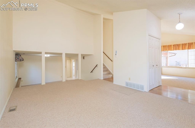 empty room with light colored carpet and high vaulted ceiling