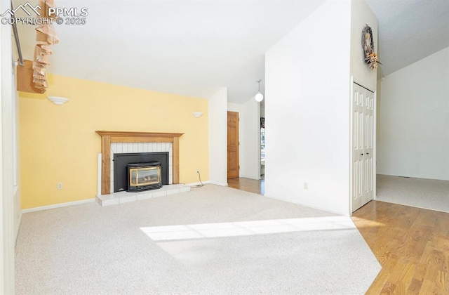 unfurnished living room with a fireplace, hardwood / wood-style flooring, and vaulted ceiling