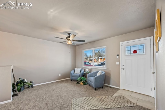 living area featuring light colored carpet and ceiling fan