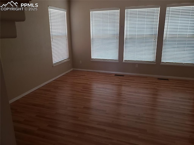 unfurnished room with dark hardwood / wood-style floors and a wealth of natural light