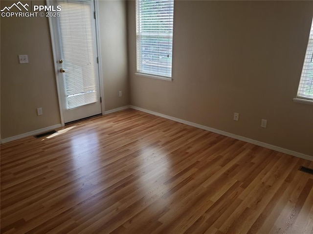 empty room with hardwood / wood-style flooring