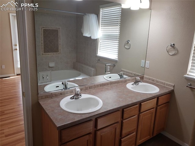 bathroom with a washtub and vanity