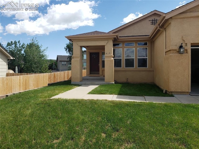 entrance to property with a lawn