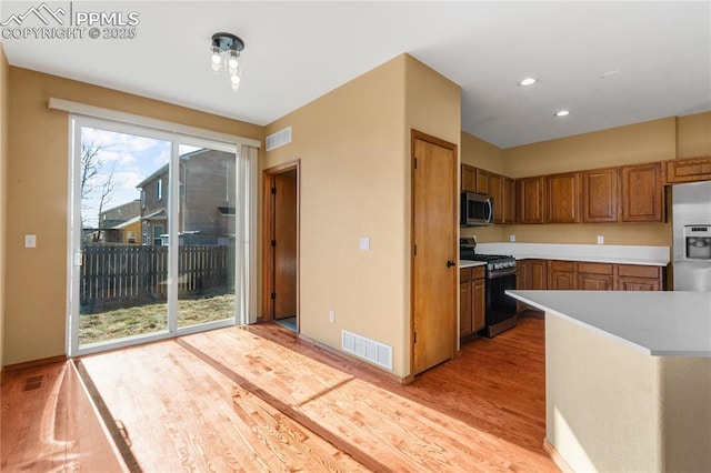 kitchen with light hardwood / wood-style floors and appliances with stainless steel finishes