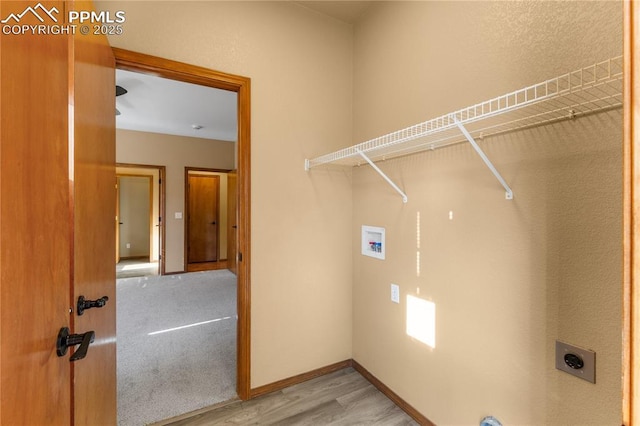 washroom with electric dryer hookup, hardwood / wood-style floors, and washer hookup