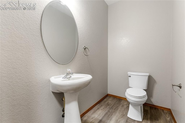 bathroom with hardwood / wood-style floors, toilet, and sink