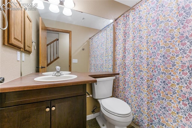 bathroom with tile patterned flooring, vanity, and toilet