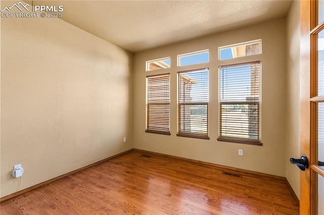 unfurnished room with hardwood / wood-style flooring