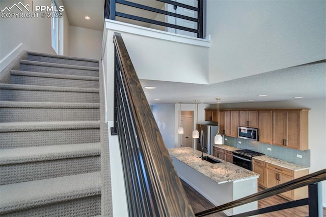 staircase featuring sink and a high ceiling