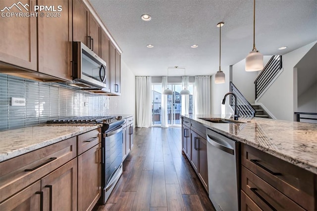 kitchen featuring pendant lighting, dark hardwood / wood-style floors, sink, and appliances with stainless steel finishes