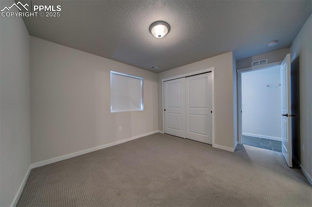 unfurnished bedroom featuring carpet flooring, a closet, and a textured ceiling