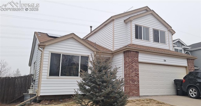 view of front of home with roof with shingles, brick siding, fence, a garage, and driveway