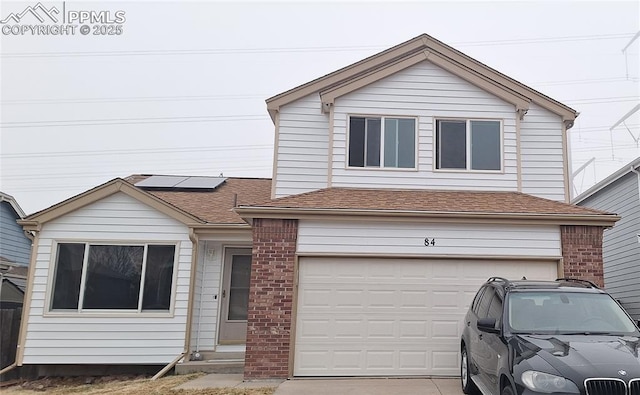 view of front of house with a garage and solar panels