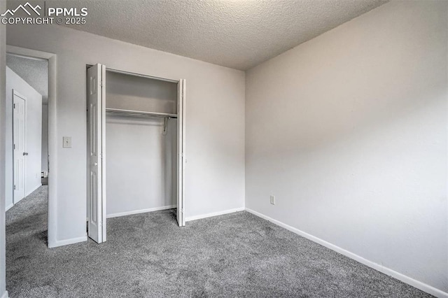 unfurnished bedroom featuring dark colored carpet, a textured ceiling, and a closet