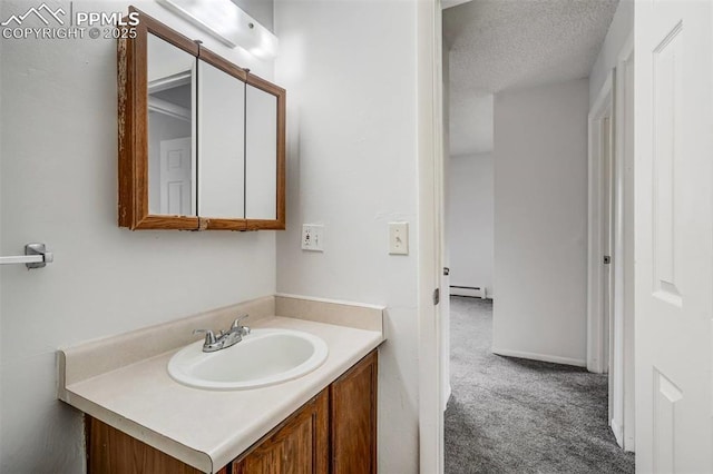 bathroom with vanity, a textured ceiling, and a baseboard heating unit