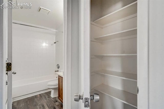 full bathroom with hardwood / wood-style floors, vanity, tub / shower combination, and toilet