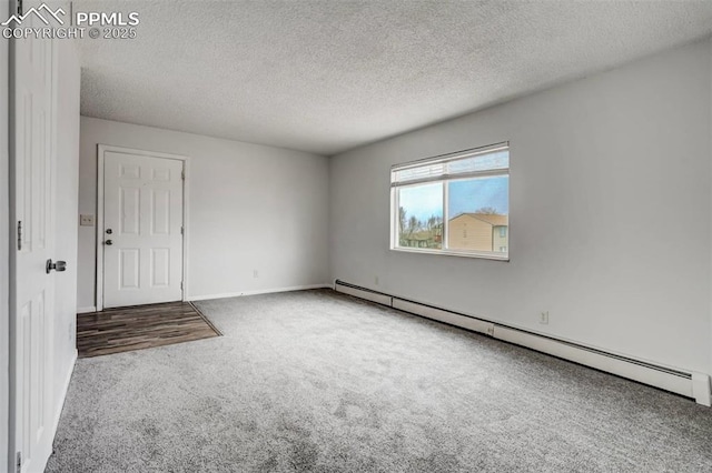 unfurnished room with a textured ceiling, carpet floors, and a baseboard heating unit