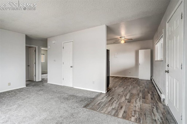 carpeted empty room featuring a textured ceiling, baseboard heating, and ceiling fan