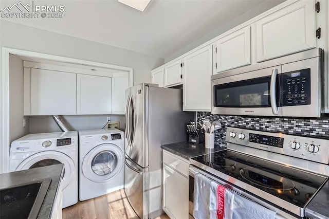 kitchen featuring tasteful backsplash, white cabinetry, sink, stainless steel appliances, and washing machine and dryer