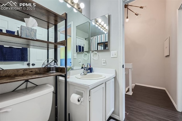 bathroom with vanity, toilet, and wood-type flooring