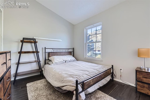 bedroom with vaulted ceiling and dark wood-type flooring