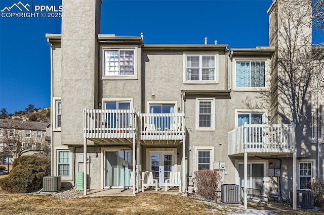 back of house featuring a balcony and central AC unit