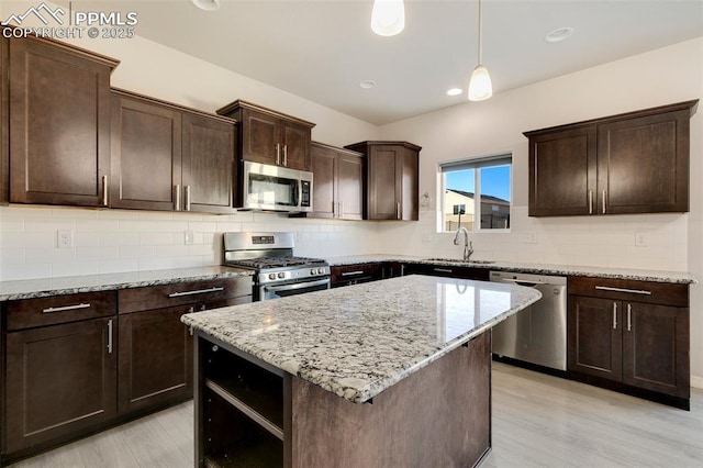 kitchen featuring dark brown cabinets, a kitchen island, hanging light fixtures, and appliances with stainless steel finishes