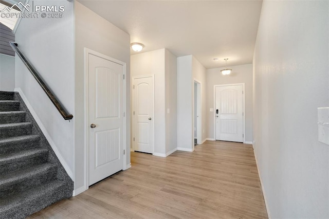 hallway with a notable chandelier and light wood-type flooring