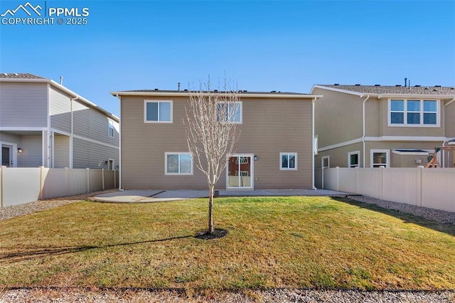 rear view of property featuring a lawn and a patio