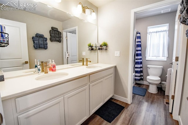 bathroom featuring wood-type flooring, vanity, and toilet