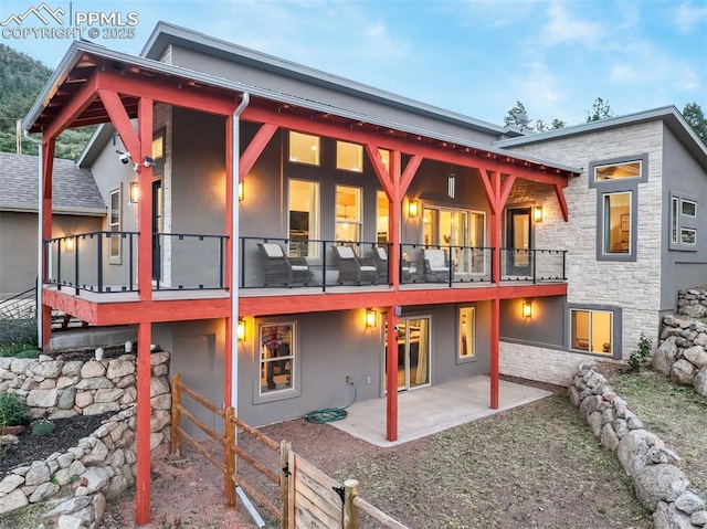 back of property with a balcony and a patio