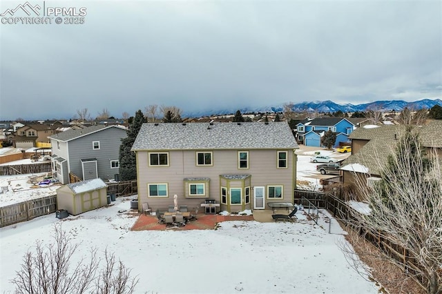 snow covered rear of property featuring a mountain view