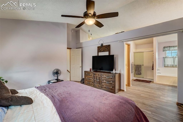 bedroom with connected bathroom, high vaulted ceiling, ceiling fan, a textured ceiling, and light wood-type flooring