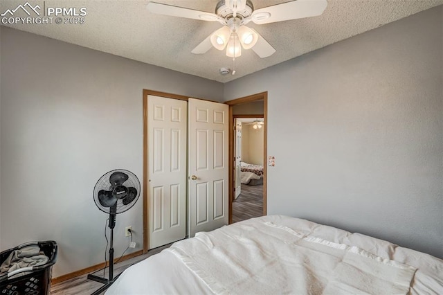 bedroom with ceiling fan, a closet, and a textured ceiling