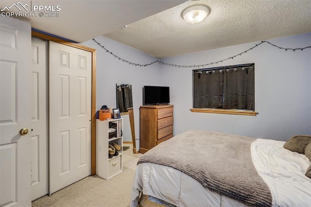 bedroom featuring a closet, a textured ceiling, and carpet