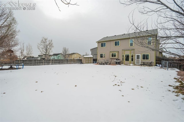 view of snow covered back of property