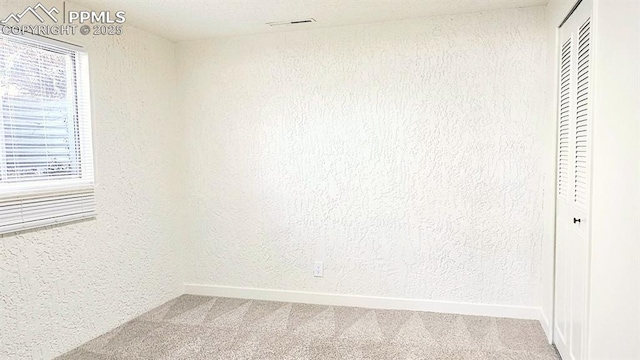 carpeted spare room featuring a healthy amount of sunlight