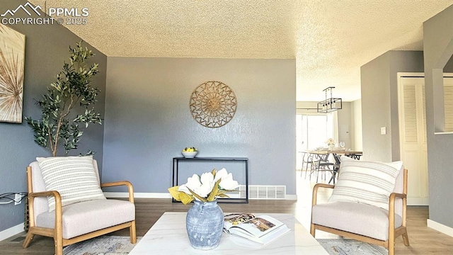 living area with wood-type flooring and a textured ceiling