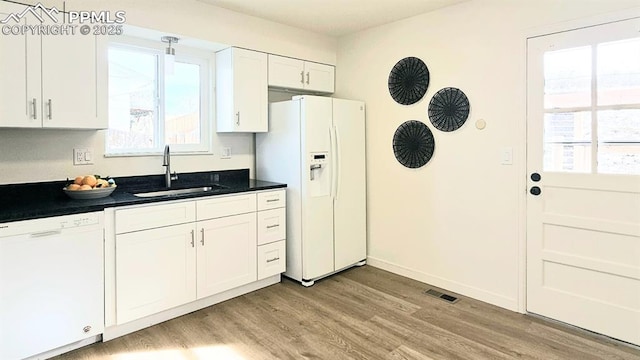 kitchen featuring white cabinetry, light wood-type flooring, white appliances, and sink