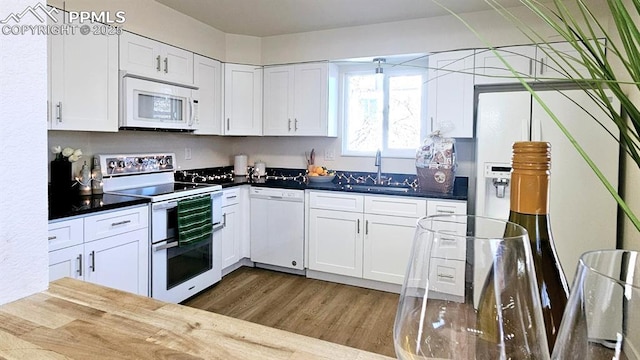 kitchen with white cabinetry, dark hardwood / wood-style flooring, white appliances, and sink