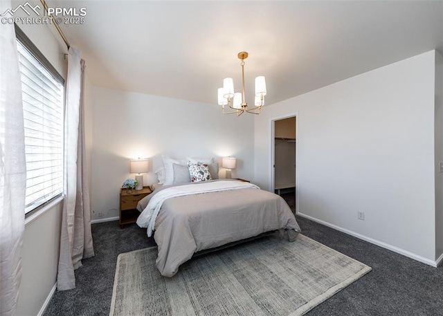 carpeted bedroom featuring a chandelier, a spacious closet, and a closet