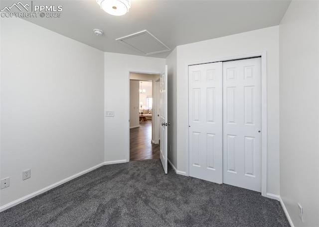 unfurnished bedroom featuring a closet and dark colored carpet