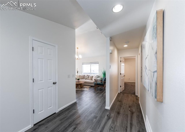 hall featuring dark hardwood / wood-style flooring and an inviting chandelier