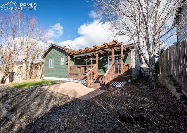 back of house featuring a pergola, a patio, and a wooden deck