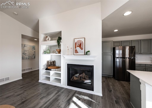 living room with dark hardwood / wood-style flooring and vaulted ceiling