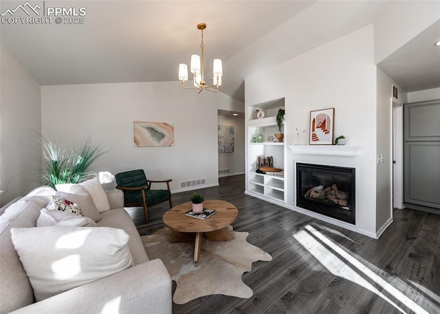 living room with built in shelves, dark hardwood / wood-style floors, vaulted ceiling, and an inviting chandelier