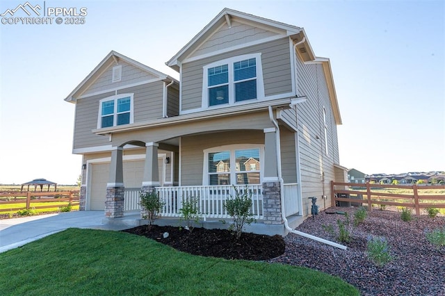 craftsman-style home featuring covered porch, a garage, and a front lawn