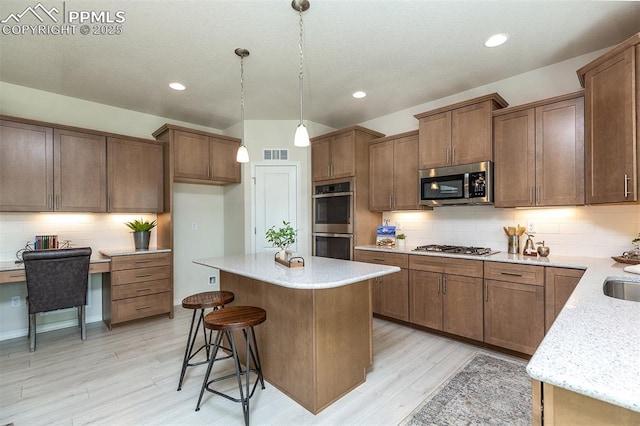 kitchen featuring light wood-type flooring, backsplash, stainless steel appliances, a center island, and hanging light fixtures