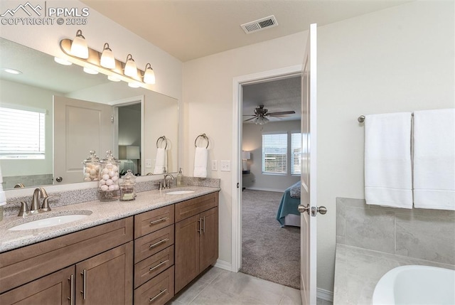 bathroom with tile patterned flooring, ceiling fan, a bathtub, and vanity