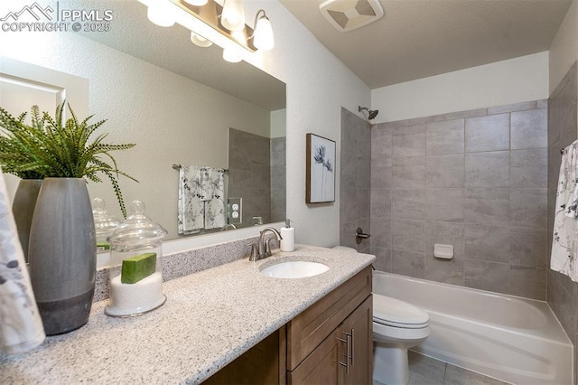 full bathroom featuring vanity, tiled shower / bath combo, toilet, and tile patterned flooring